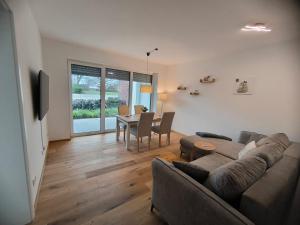 a living room with a couch and a table at SeeZeitApartments Whg 28 in Lembruch