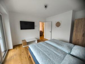 a bedroom with a bed and a flat screen tv at SeeZeitApartments Whg 28 in Lembruch