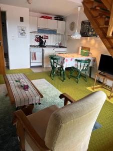 a living room with a table and chairs and a kitchen at Ferienwohnung Ewa in Grassau
