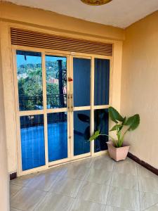 a room with a large window with a potted plant at Stylish Smart Studio Apartment in Kampala