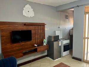 a living room with a flat screen tv on a wall at Stylish Smart Studio Apartment in Kampala