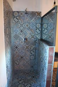 a bathroom with a shower with mosaic tiles on the wall at Le Dimore di San Nicola in Favara +123 photos