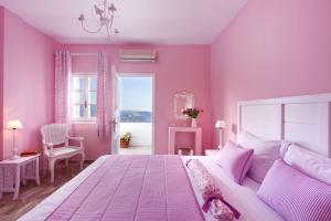 a bedroom with pink walls and a pink bedspread at Senses Boutique Hotel in Imerovigli