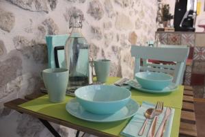a table with plates and bowls and a bottle on it at Le Dimore di San Nicola in Favara