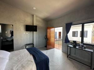 a bedroom with a bed and a television and a bathroom at Casa de los Agaves in Bernal