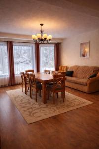 a dining room with a table and chairs and a couch at Cabana Valea Muntelui in Poiana Mărului