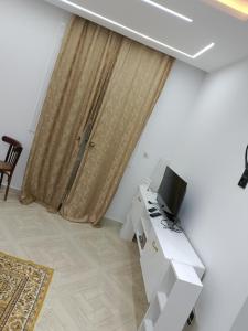 Adel Summer Annaba في عنابة: غرفة معيشة مع ستارة وتلفزيون