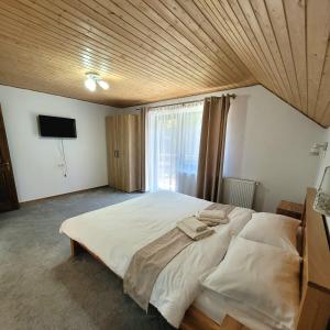 a bedroom with a large bed with a wooden ceiling at Cabana Valea Muntelui in Poiana Mărului +13 photos