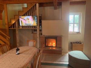 a living room with a table and a fireplace at Vikendica PEPO in Blidinje