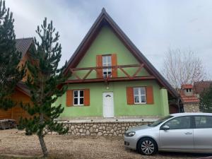 a house with a car parked in front of it at Vikendica PEPO in Blidinje