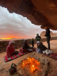 瓦迪拉姆Wadi Rum Desert Experience的一群人围坐在 ⁇ 火旁