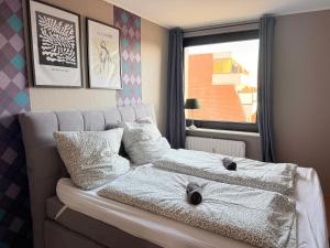 a bedroom with a couch with pillows and a window at Schöne 3-Zimmer City-Wohnung in Neumünster