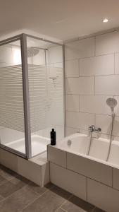 a large white bathroom with a tub and a shower at Wohnung für 7 Personen in Hückelhoven +41 photos