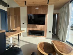 a living room with two chairs and a tv on a wall at Avithos Blue Villas in Svoronata