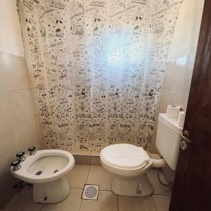 a bathroom with a toilet and a sink at Alojamiento Goos in Puerto Pirámides +28 photos