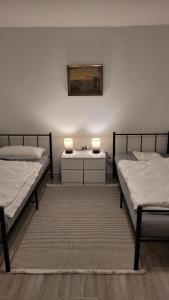 two beds in a room with two lamps and a rug at Wohnung für 7 Personen in Hückelhoven