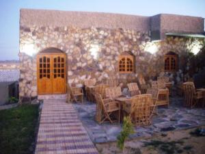 a stone building with tables and chairs in front of it at Sandrose Baharia Hotel in Bawati