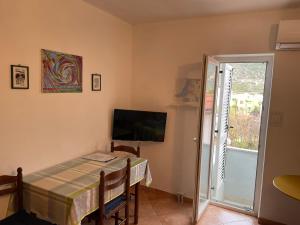 una sala da pranzo con un tavolo e una televisione di Apartment Orbanić Cres a Cres