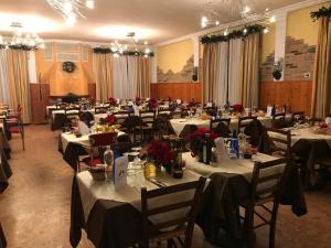 a large banquet hall with tables and chairs with red flowers at Hotel Oasi Este in Este