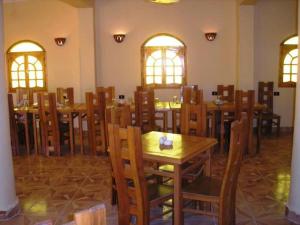 a dining room with wooden tables and chairs at Sandrose Baharia Hotel in Bawati