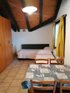 una camera da letto con due letti, un tavolo e delle sedie di Al Fogolar a Villa Santina