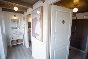 een badkamer met een witte deur en een wastafel bij Mosters Bed & Breakfast in Guldborg