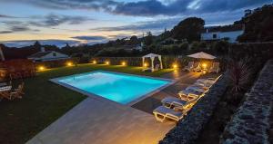 een achtertuin met een zwembad en ligstoelen bij Casa de Campo Franco da Serra in Angra do Heroísmo