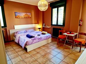 una camera da letto con un letto, un tavolo e delle sedie di BERNINA STATION CENTRE APARTMENT 1 - 30 seconds walk from bernina station a Tirano