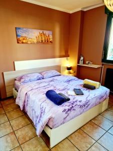 una camera da letto con un letto grande con lenzuola viola di BERNINA STATION CENTRE APARTMENT 1 - 30 seconds walk from bernina station a Tirano