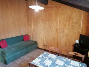 un soggiorno con un divano verde e un tavolo di Al Fogolar a Villa Santina