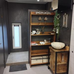 een kamer met een plank met items erop bij Voormalige Gevangenis Cel bij B&B Gezond aan Zee - Toegang Wellnesstuin meerprijs in Ouddorp