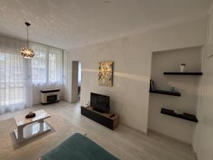 een woonkamer met een bank en een tv bij Bella Apartman in Békéscsaba