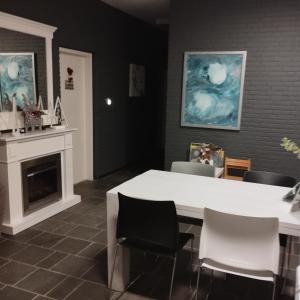 een eetkamer met een witte tafel en stoelen bij Voormalige Gevangenis Cel bij B&B Gezond aan Zee - Toegang Wellnesstuin meerprijs in Ouddorp