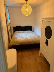 a small bedroom with a bed and a chandelier at Bed & Breakfast Anna in Groningen