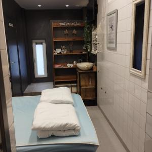 twee witte kussens op een bed in een kamer bij Voormalige Gevangenis Cel bij B&B Gezond aan Zee - Toegang Wellnesstuin meerprijs in Ouddorp