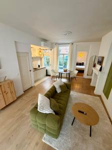 a living room with a green couch and a table at Bed & Breakfast Anna in Groningen