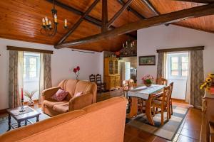 a living room with a couch and a table at Rustic House - Eco Farm Living in Capelas