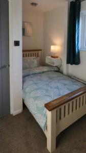 ein Schlafzimmer mit einem Bett mit blauer Bettdecke in der Unterkunft Witz End in Corsham