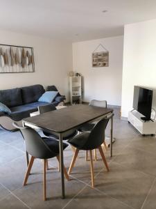 a living room with a table and chairs and a couch at maison de village in Renaison