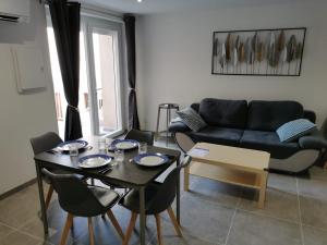 a living room with a table and a couch at maison de village in Renaison