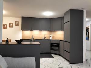 a kitchen with black cabinets and a kitchen island at Ferienwohnung Paradiso 1 in Grächen