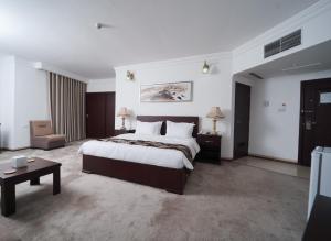 a large hotel room with a bed and a table at Al-Assadi Hotel in Erbil +23 photos