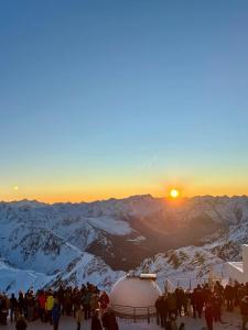 una folla di persone in piedi sulla cima di una montagna coperta di neve di La Maison aux pieds des Pyrénées - Piscine d'exception de 25m a Espoey