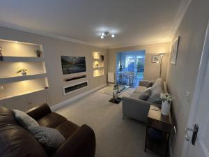 a living room with two couches and a tv at Siskin House in Wickham Market