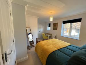 a bedroom with a bed and a desk and a window at Siskin House in Wickham Market