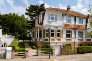 a white house with a red roof at Villa-Sabbia in Koksijde