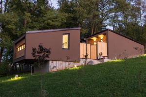 a small house on a hill with lights on it at BLOK Wood Cottage in Visoko