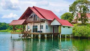 a house on a dock in the water at Six Pillars Resort in Bocas Town