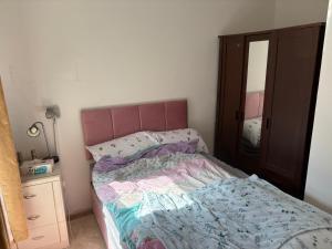 a bedroom with a bed and a dresser and a mirror at Treforest Cwtch House in Treforest