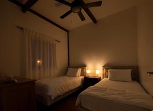 a bedroom with two beds and a ceiling fan at Six Pillars Resort in Bocas Town